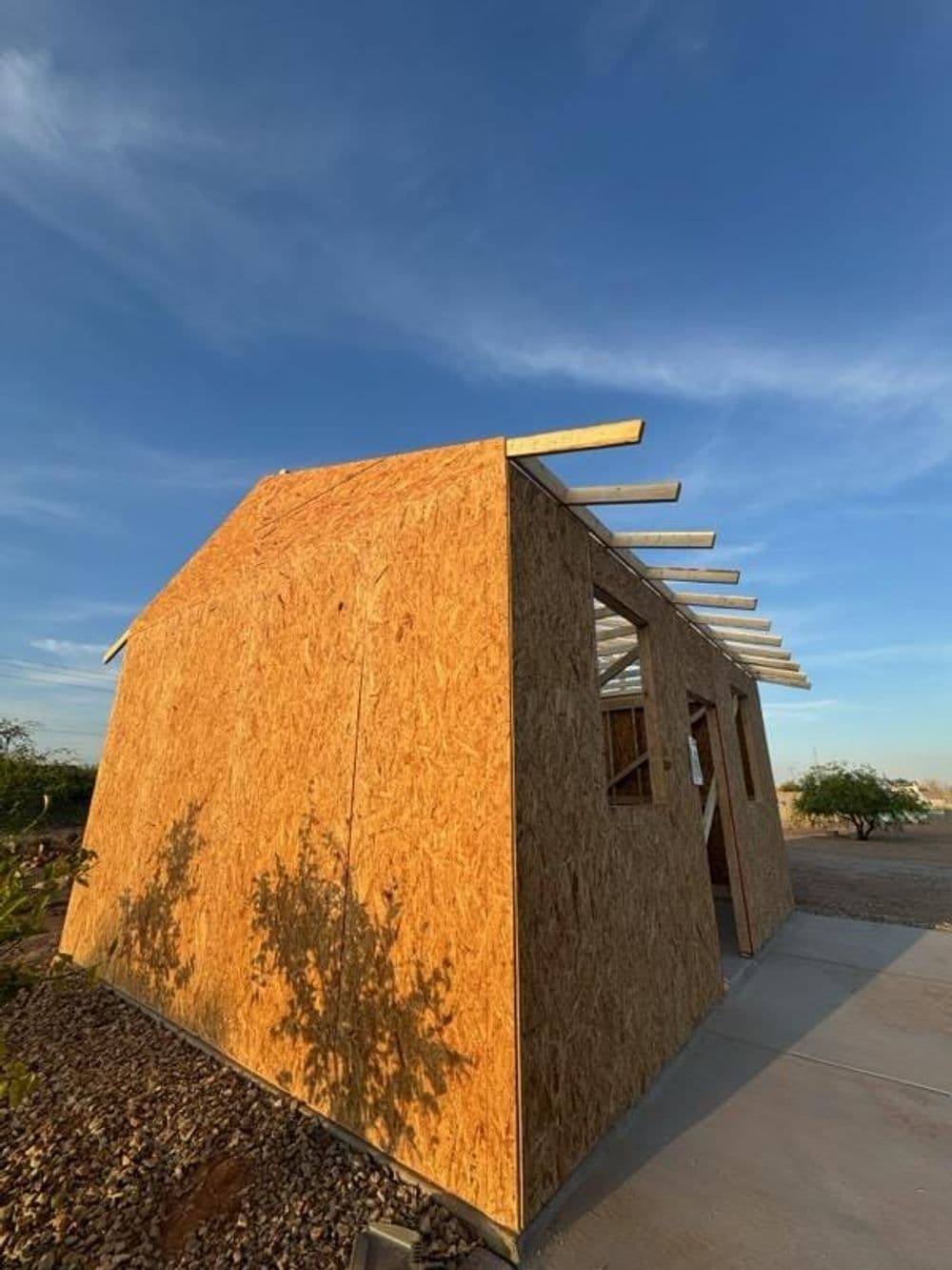 Modern eco-friendly home under construction with wooden frame and clear sky backdrop.