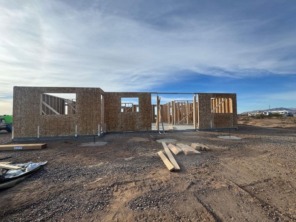 Construction site featuring an incomplete building framework against a blue sky.