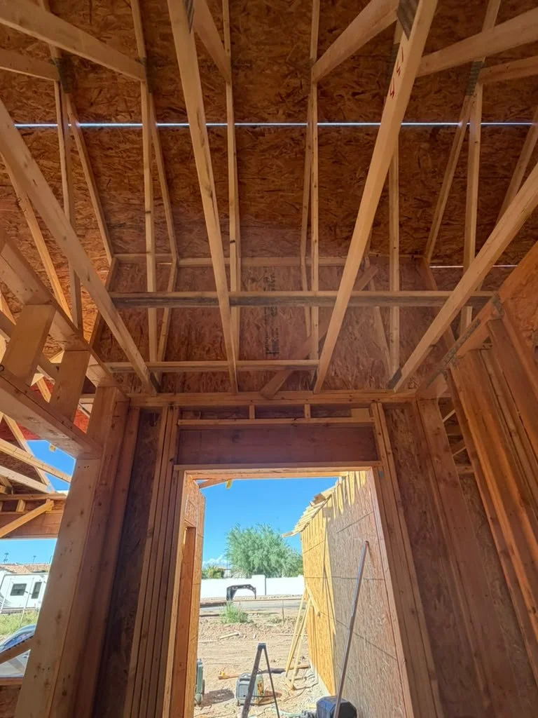 An interior doorway beneath exposed framing