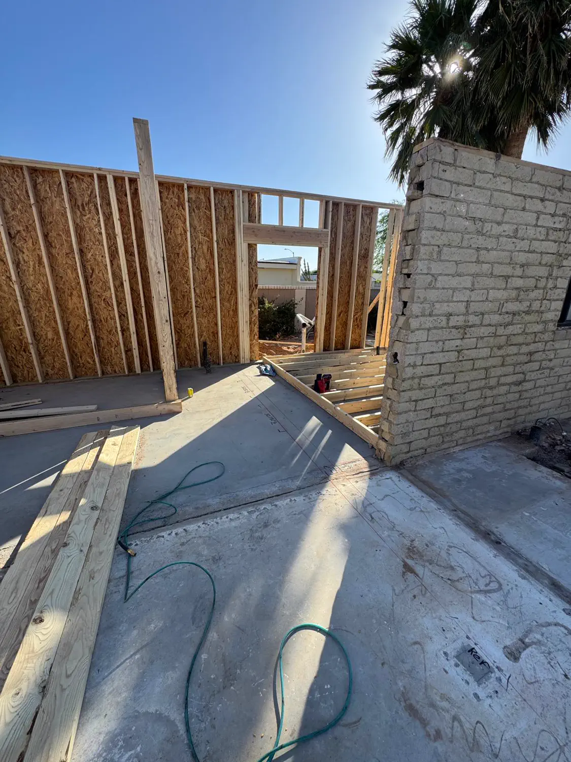 Afternoon shadows across framed walls and a finished slab