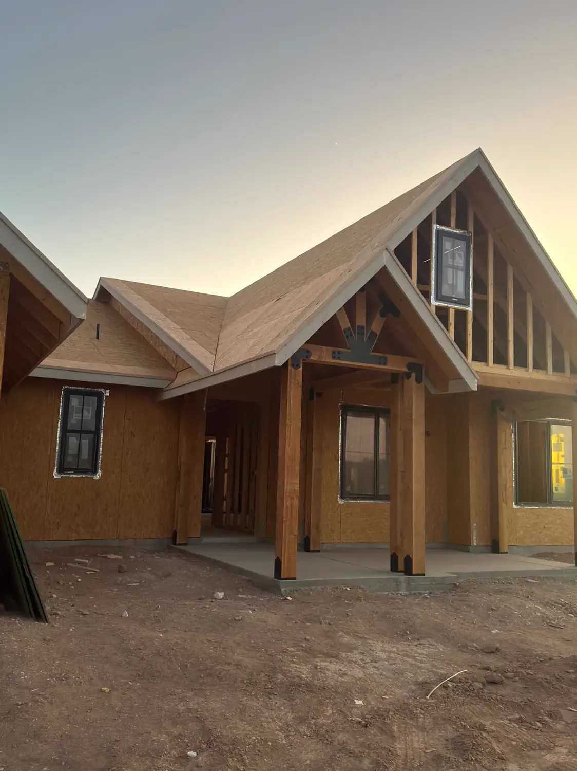 The front porch and timber posts of a custom home at dusk