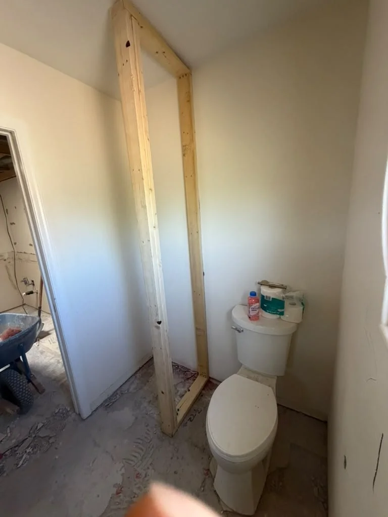 Framed wall work beside a bathroom fixture