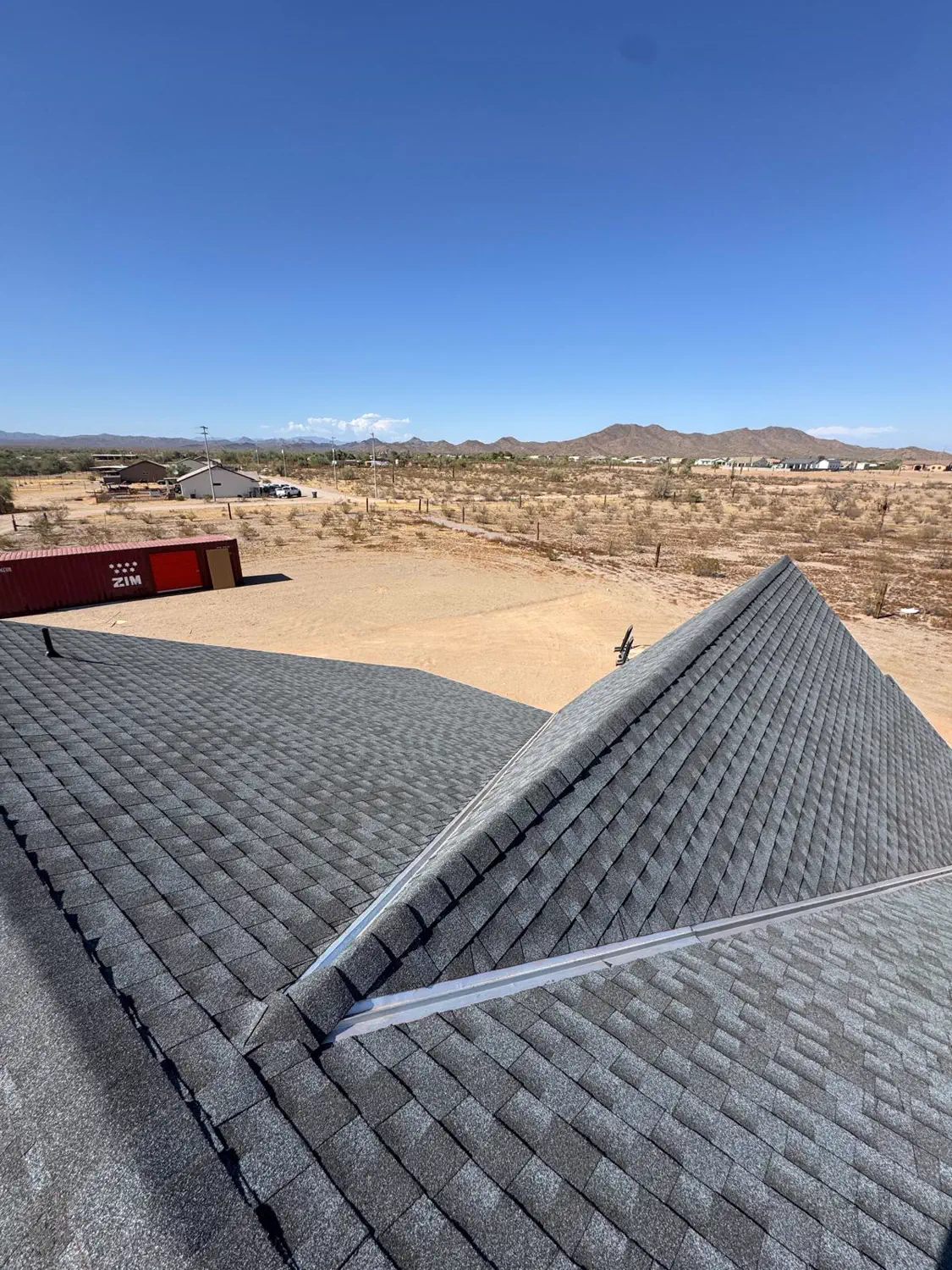 A newly shingled hip roof with the Arizona mountains beyond