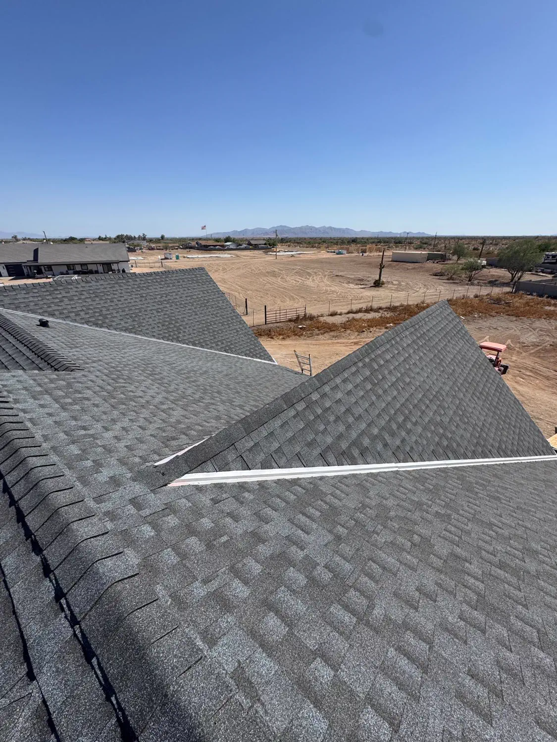 A shingled roof valley with the desert beyond