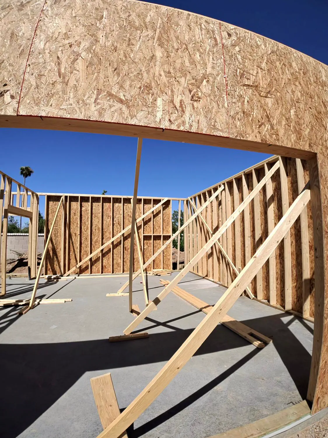 A curved sheathed wall braced over a finished slab