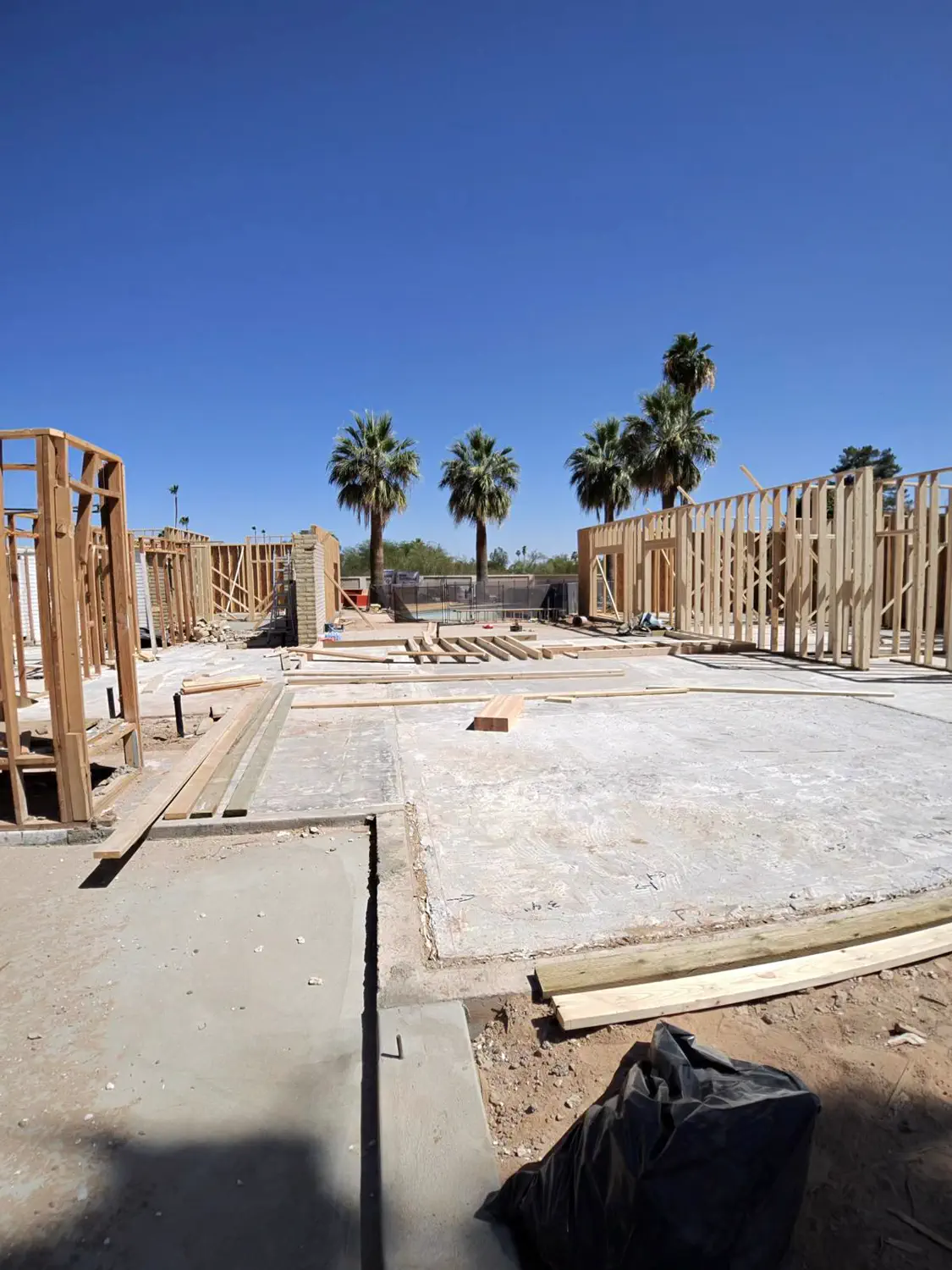 A poured slab with the first framed walls standing along one edge