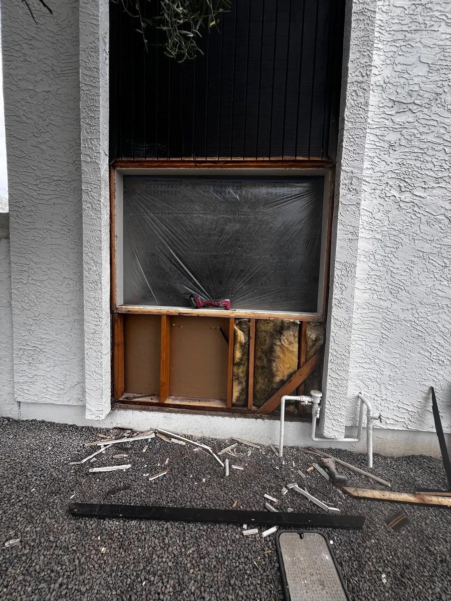 A wall opened up and the old window taken out, ready for a wider one