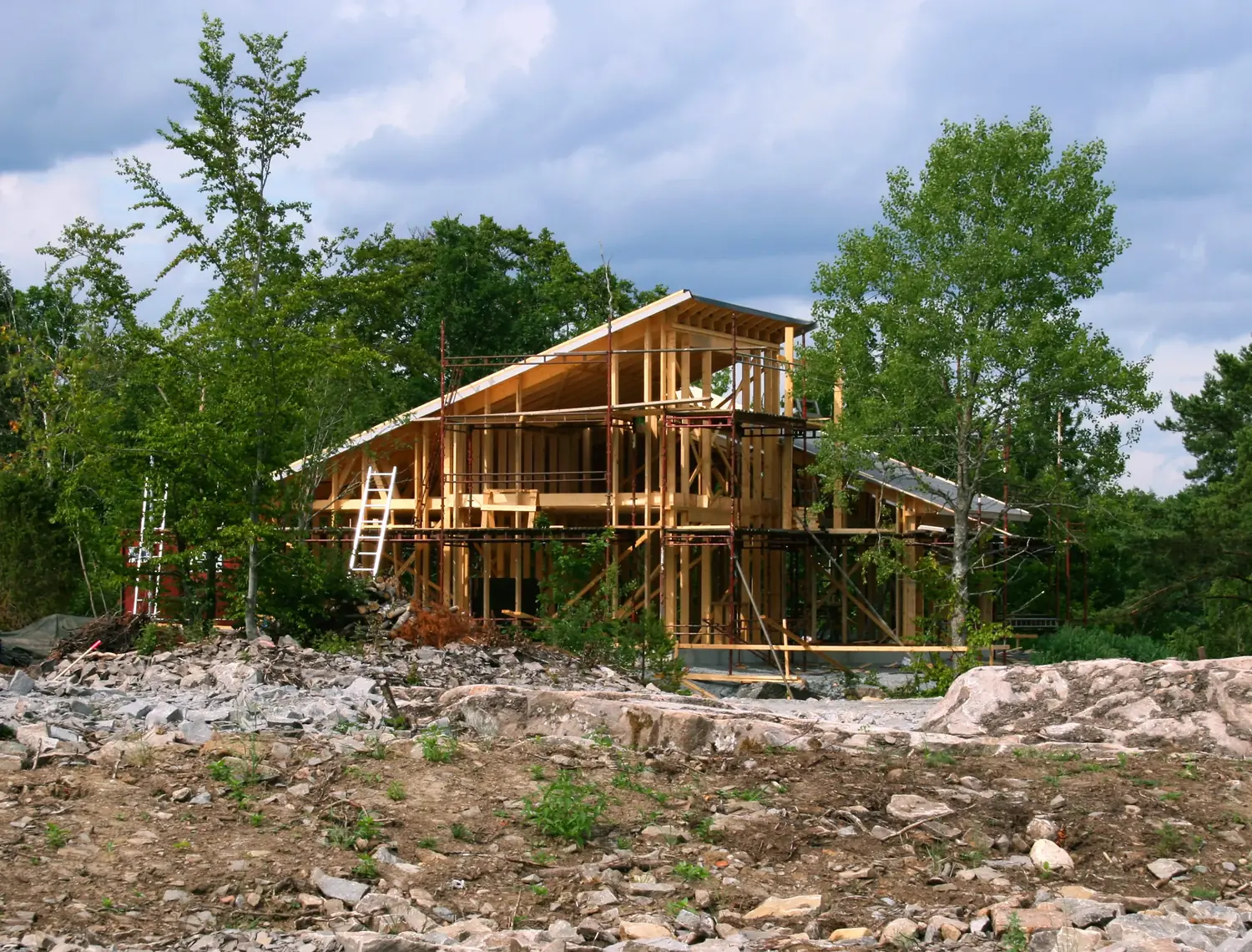 A house standing in open timber frame on a cleared lot