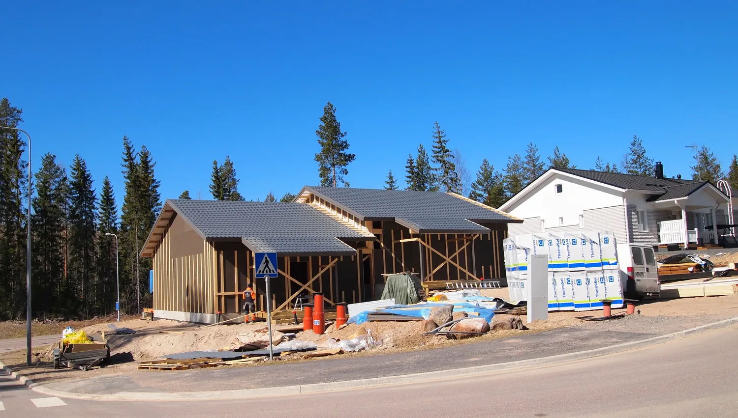 New houses going up along a street, still in frame and sheathing