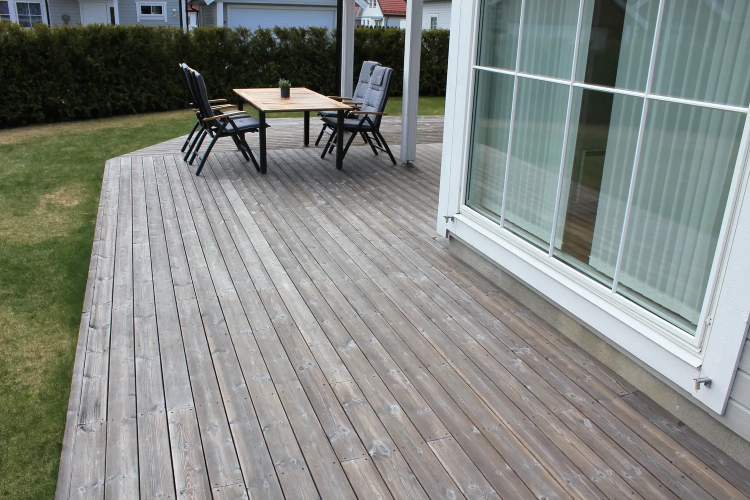 A finished timber deck running up to full-height glazing