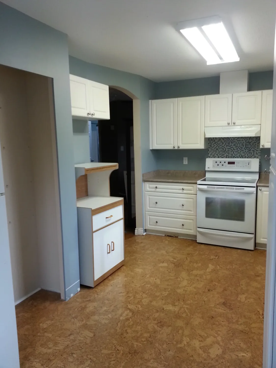 A fitted kitchen with wall cabinets, worktop and oven in place