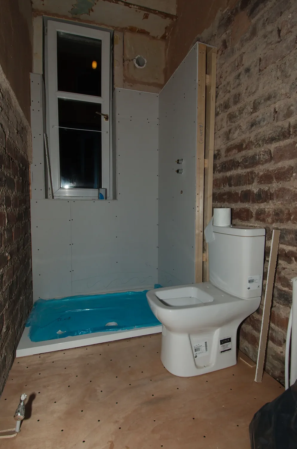A bathroom stripped back to the brickwork partway through a refit